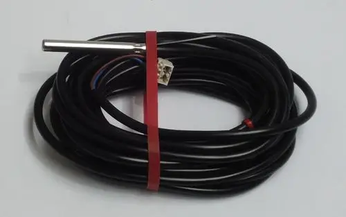 Daikin Sensor mit metallischem Gehäuse und Kabel, aufgerollt und mit einem Stecker versehen, für die Verwendung in Heizsystemen konzipiert.